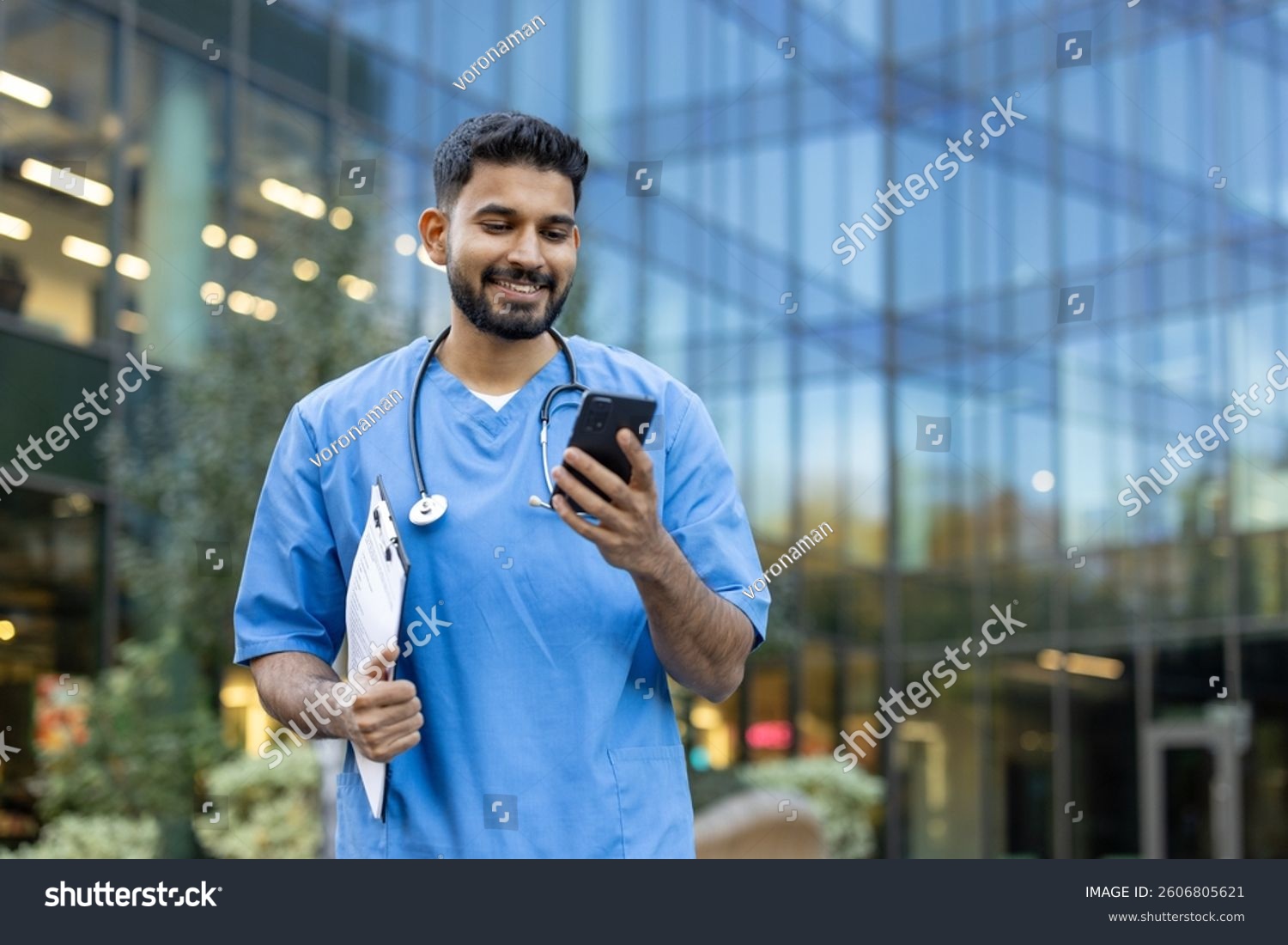 Healthcare professional smiling while using a phone